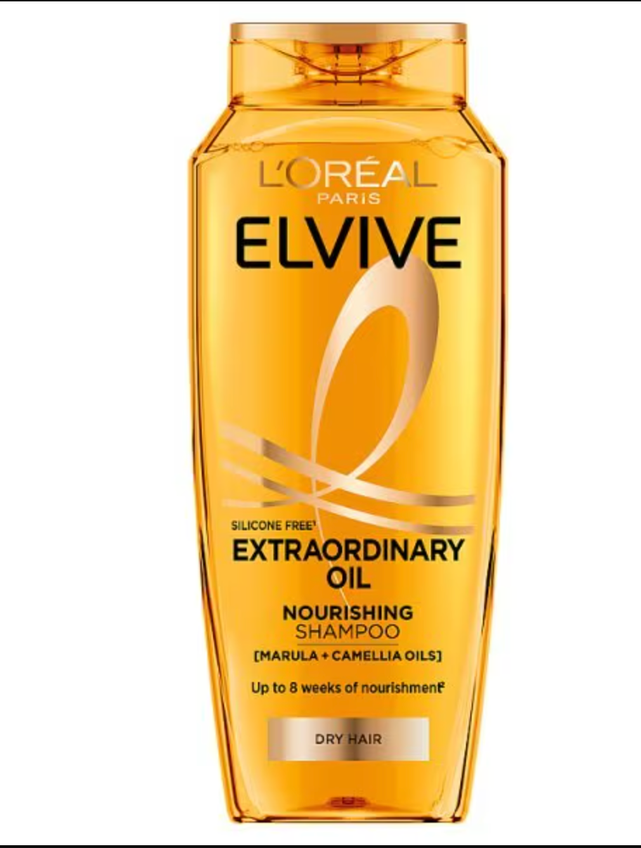 L'Oréal Paris Elvive Extraordinary Oil Shampoo bottle on bathroom counter with clean towels