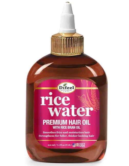 Difeel Rice Water Premium Hair Oil bottle on wooden surface with rice grains scattered around