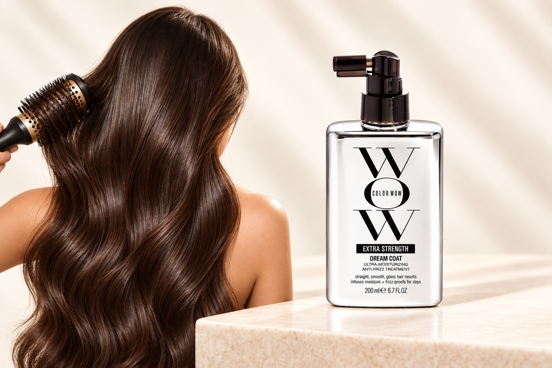 Color Wow Extra Strength Dream Coat bottle beside smooth dark hair and a round brush.