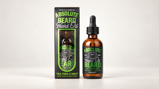 Tyche Absolute Tea Tree & Mint Beard Oil amber dropper bottle and black-and-green carton on an ivory background