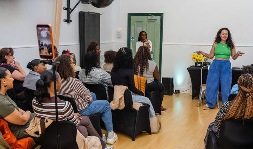 Presenter speaking to the workshop audience beside a seated volunteer.
