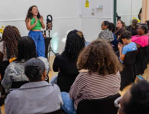 Presenter in a green top speaking to workshop attendees.