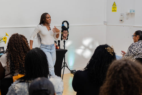 Workshop presenter holding a styling mannequin head.