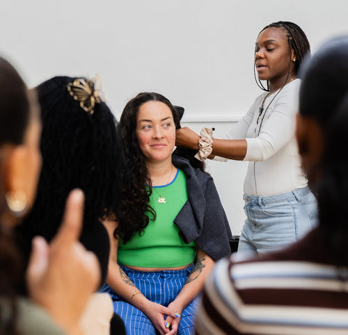Close view of a presenter demonstrating hair care on a volunteer.