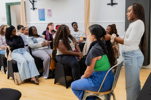 Attendees watching a hair care demonstration.