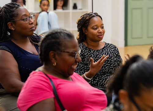 Attendee in a pink top listening during the workshop.