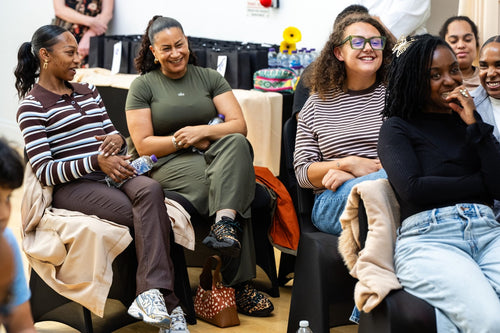 Seated participants smiling and chatting at the workshop.