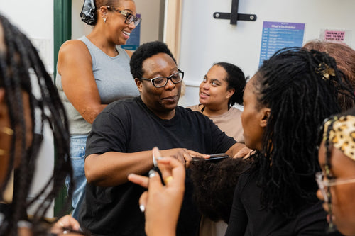 Participants practising a hands-on hair care technique.