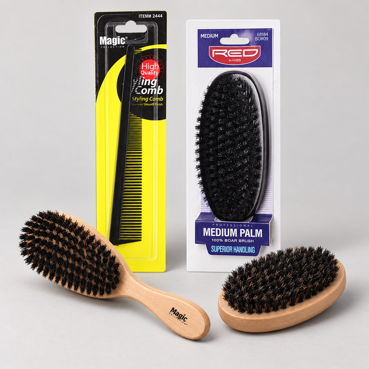 A barber comb, wooden wave and palm brushes, and a packaged Red by Kiss brush on a light studio background.